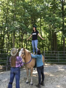 Girl standing on horse